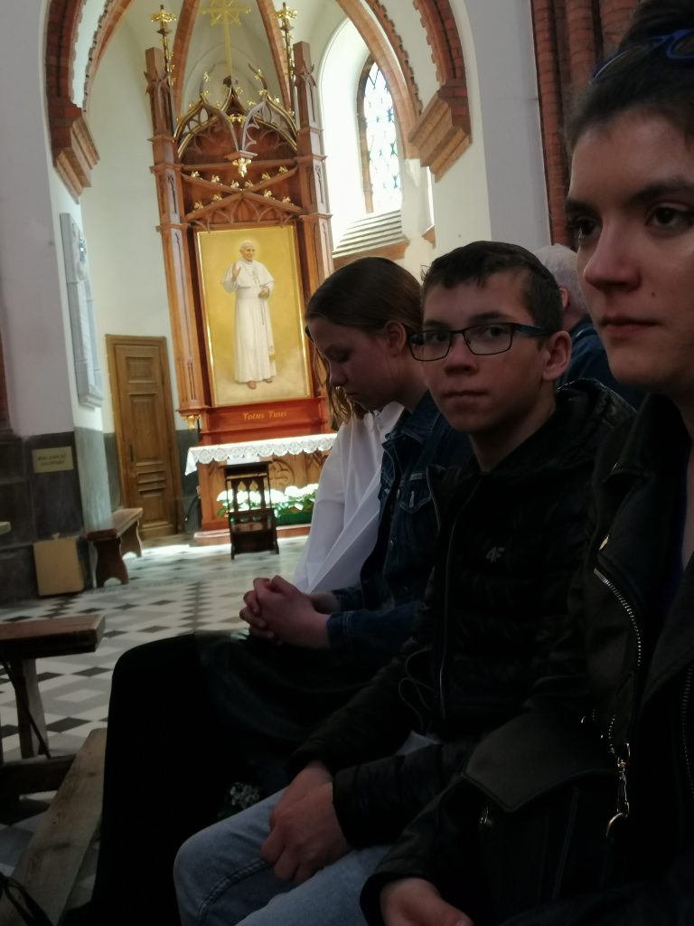 młodzi ludzie siedzą w kościele