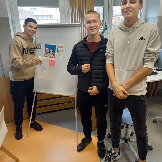 trzech młodych chłopców stoi na tle białej tablicy