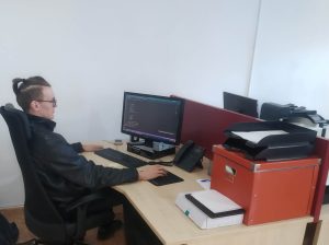 młody chłopak siedzi przy biurku przy komputerze