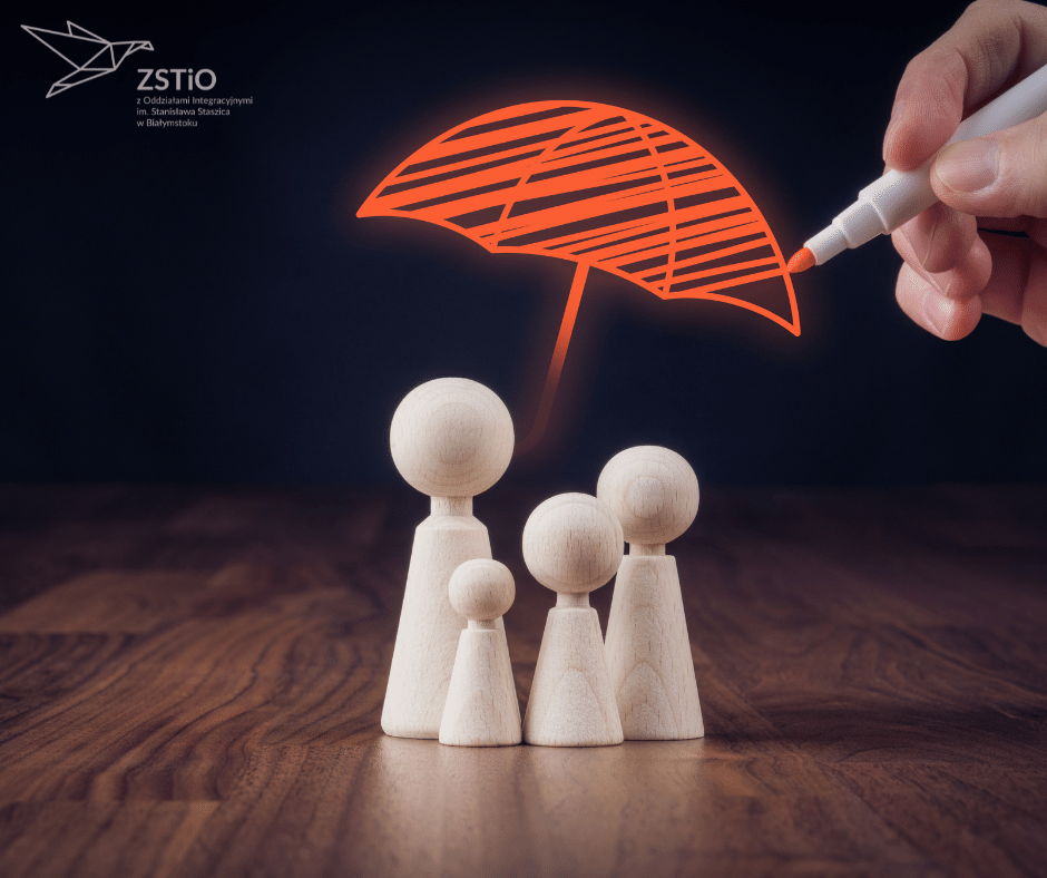 cztery figurki drewniane przypominające człowieka, na górze czerwony parasol rysowany flamastrem trzymanym w dłoni