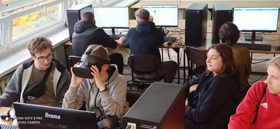 grupa młodych ludzi, sala informatyczna, komputery