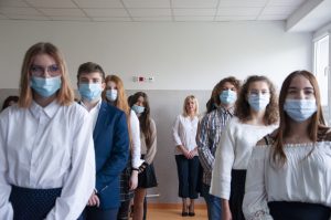 młodzi ludzie w białych bluzkach stoją w 2 rzędach