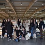 grupa ludzi na pseudowidokowym tarasie wewnątrze hali