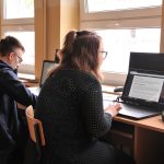 uczniowie pracujący na laptopach