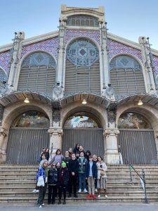 grupamłodych ludzi pozuje do zdjecia na tle zabytkowego budynku