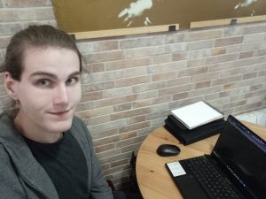 młody chłopak siedzi przy biurku przy komputerze