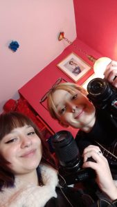 dwie młode dziewczyny z aparatami pozują do zdjecia