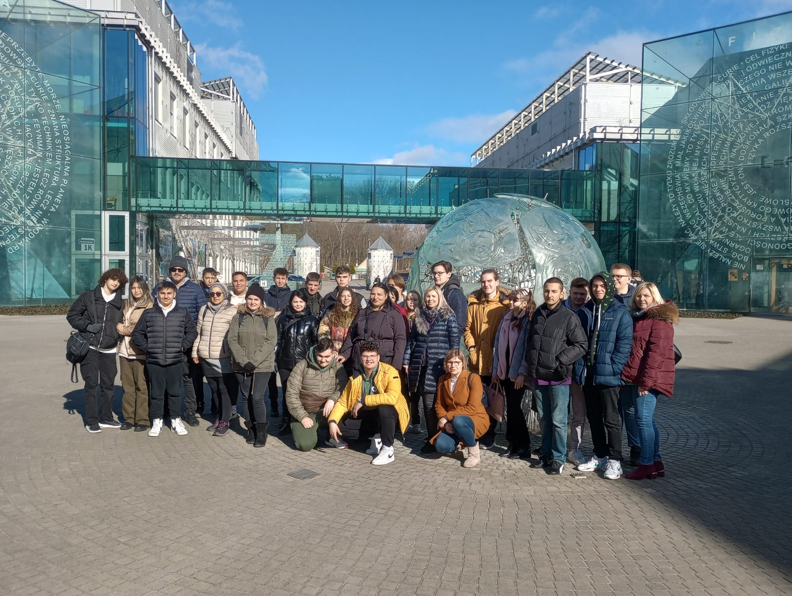 grupa ludzi na tle szklanego budynku