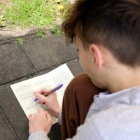 młody chłopak zapisuje tekst na kartce