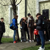 grupa młodych ludzi stoi obok budynku