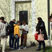 grupa młodych ludzi stoi obok budynku